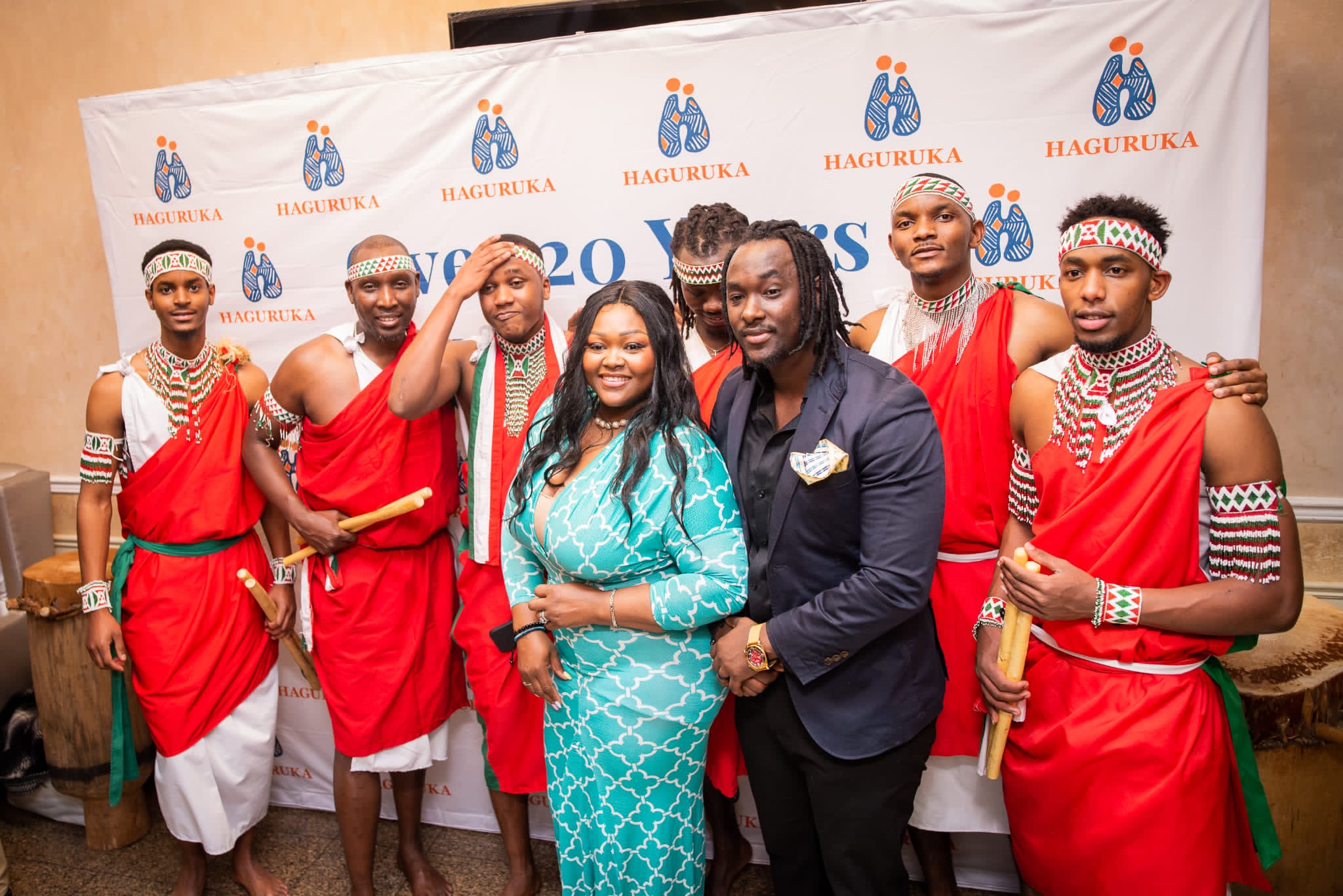 The ensemble with event hosts in front of a sponsor backdrop
